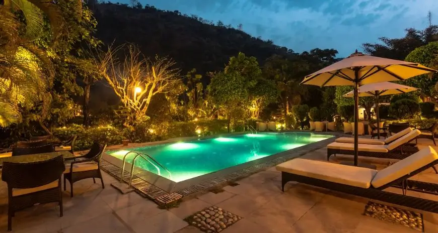 Luxury resort pool surrounded by tropical gardens and hills